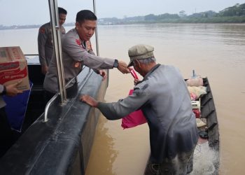Kapolda Jambi menyerahkan bantuan kepada nelayan yang sedang mencari ikan, yang ia temui di pinggiran Sungai Batanghari Selasa (3/1/2023). (dok Humas Polda Jambi)