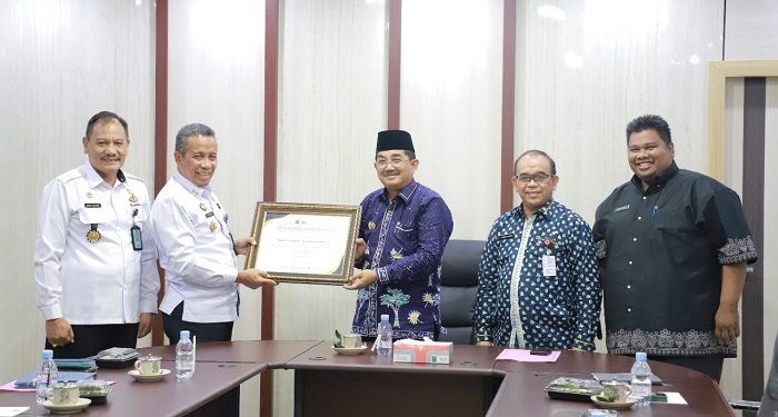 Bupati Tanjungjabung (Tanjab) Barat, Anwar Sadat, saat menerima penghargaan dari Kepala Kantor Kemenkumham Wilayah Jambi, Kamis (19/1/2023). (Foto Wahyu)
