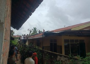 Petugas dan warga 19, Kelurahan Paal V, Kecamatan Kotabaru, Kota Jambi mengevakuasi ODGJ yang ngamuk dan naik ke atap rumah warga pada Kamis (19/1/2023). (Foto Reza)