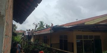 Petugas dan warga 19, Kelurahan Paal V, Kecamatan Kotabaru, Kota Jambi mengevakuasi ODGJ yang ngamuk dan naik ke atap rumah warga pada Kamis (19/1/2023). (Foto Reza)