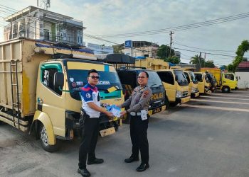 Pihak Kepolisian Resor Kota Jambi menunjukkan surat tilang di depan lima mobil angkutan batu bara yang melanggar. (Foto Reza)