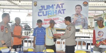 Kabid Humas Polda Jambi, Kombes Pol Mulia Prianto, menyerahkan bantuan beras kepada salah satu masyarakat yang hadir dalam kegiatan Jum'at Curhat, (10/2/2023). (Foto Humas Polda Jambi)