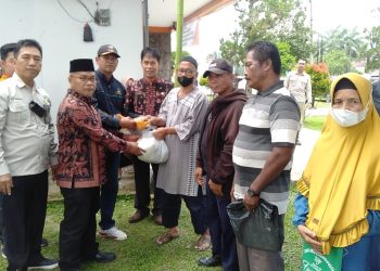 Muktamar Hamdi, menyerahkan secara simbolis paket sembako kepada masyarakat di Kantor pos Pijoan Kab. Muara jambi, Kamis (20/04/20). (Foto : Harun - Kominfo)