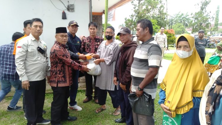 Muktamar Hamdi, menyerahkan secara simbolis paket sembako kepada masyarakat di Kantor pos Pijoan Kab. Muara jambi, Kamis (20/04/20). (Foto : Harun - Kominfo)